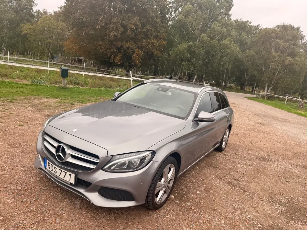 Kundens eget foto av en silvergrå Mercedes-Benz C-Klass kombi på en grusplan